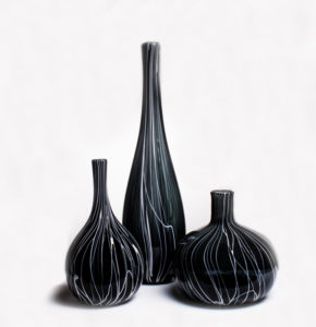 Three black vases, each with white swirls from bottom to top, by Skitch Manion
