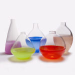Five glass containers with the bottom halves painted purple, yellow, blue, red, and tan by Skitch Manion