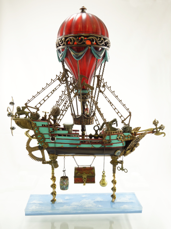 Found object sculpture of a green ship with gold accents, flying by hot air balloon over a sky blue panel, by Larry Agnello