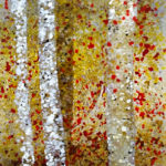 Detail of a fused glass panel with white and yellow rods with pieces of red sprinkled in by Katherine Cheetham