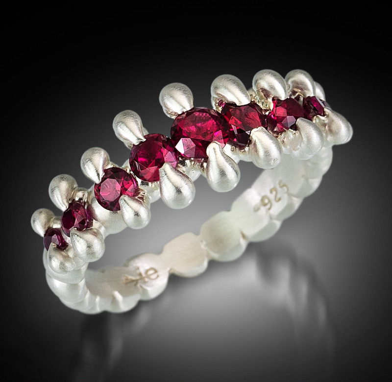 Sterling silver ring lined with ruby red gems. created by Isabelle Ecker.