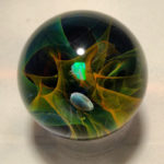 Closeup of glass with a nebula of blue, green, and orange suspended in the glass. by Bill Futer