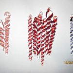 A collection of swirled glass icicles in peach, red, and gray by Bill Futer