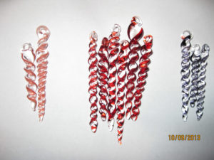 A collection of swirled glass icicles in peach, red, and gray by Bill Futer