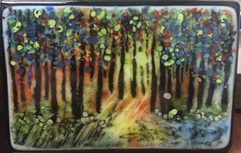 Painted glass panel depicting a forest scene with orange, yellow, green, and blue accents. Created by artist Charlyn Moellers