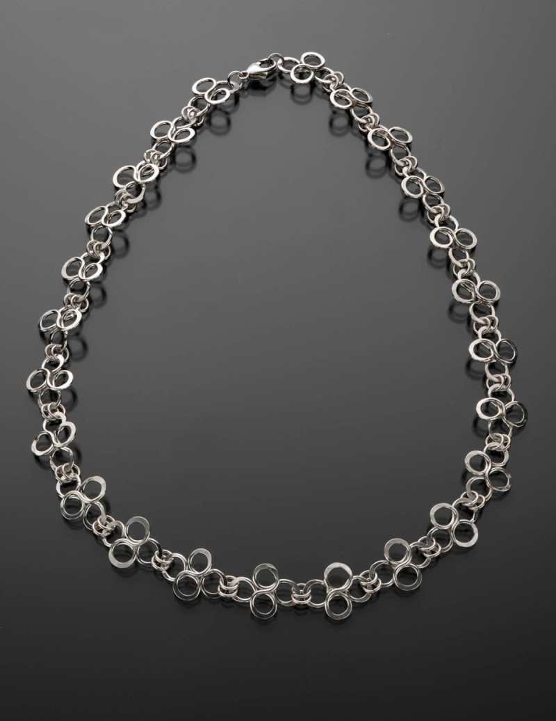 Silver necklace shaped into sets of intersecting infinity symbols, with lobster claw clasp. Created by Mary Beth Nardy
