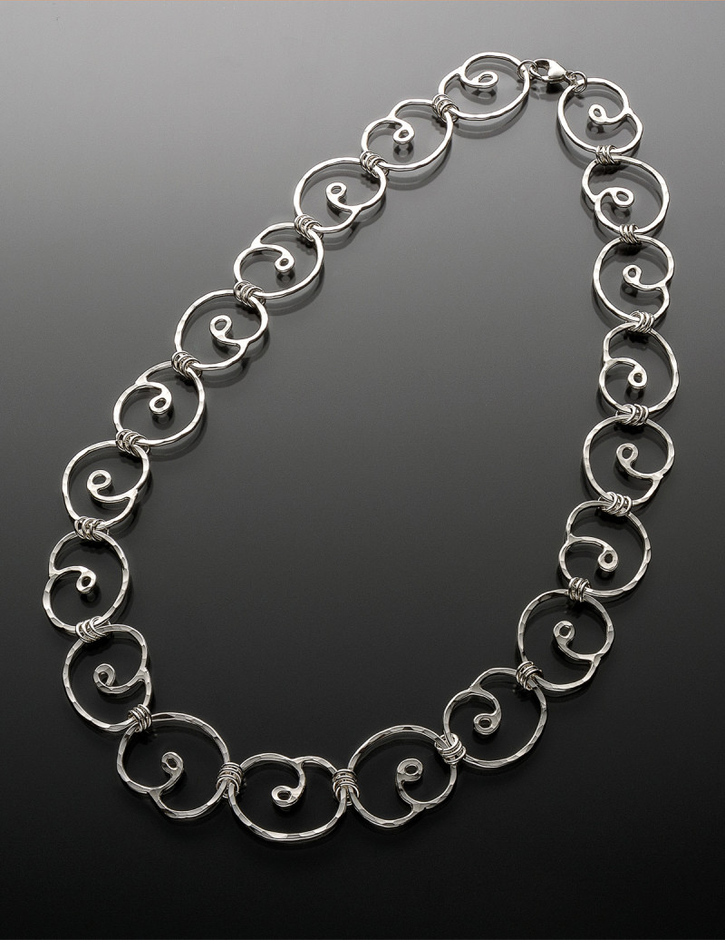 Precious metal clay shaped into 20 spirals with small silver links and lobster claw clasp. Created by Mary Beth Nardy.