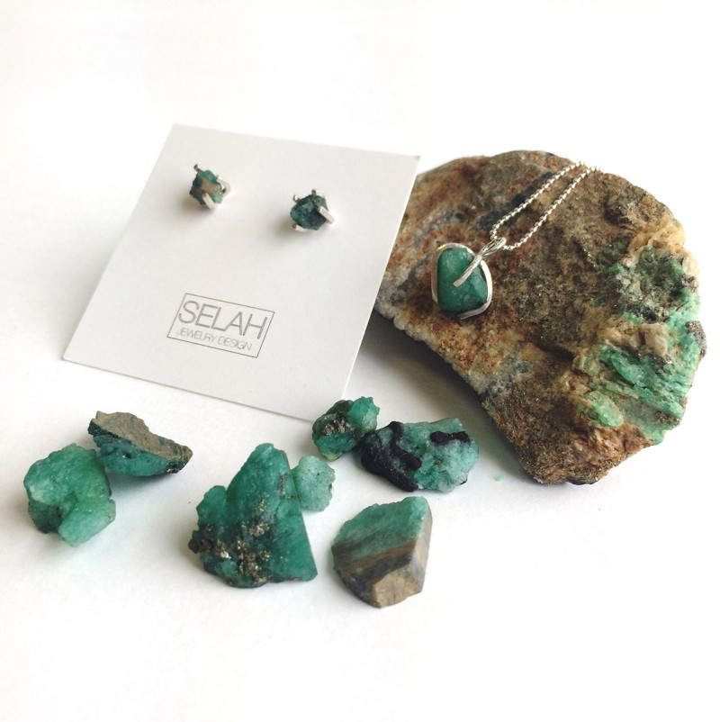 Green gem earrings with silver bezel and matching necklace on a raw piece of mineral. Created by Angel Mauricio Riano Diaz.