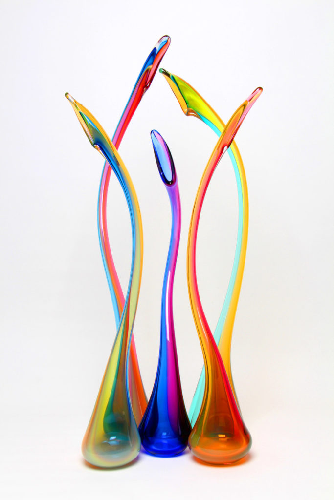 Multicolored glass piece with 5 winding stems reaching upward. Created by artist Joshua Solomon.