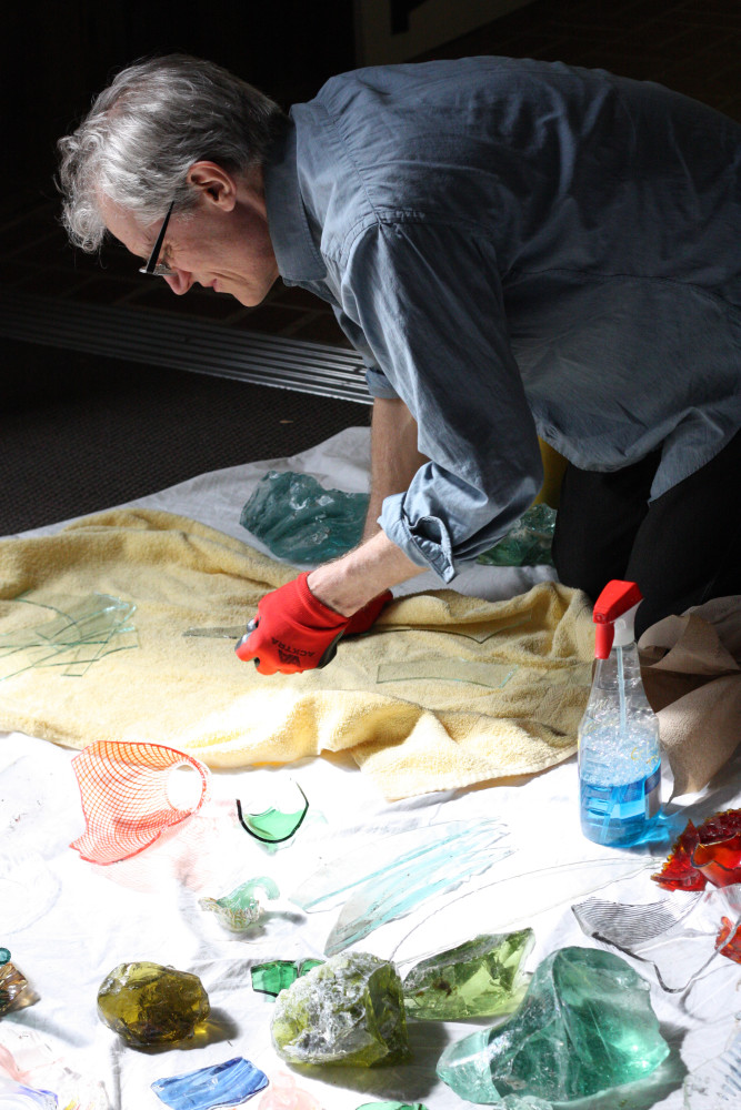 Richard Torchia cleaning the broken pieces of glass that will go into a drum of the Kaleidoscope.