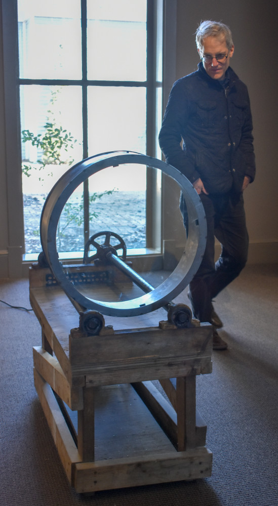 Richard Torchia standing next to the ball mill motor and drum skeleton of his kaleidoscope.