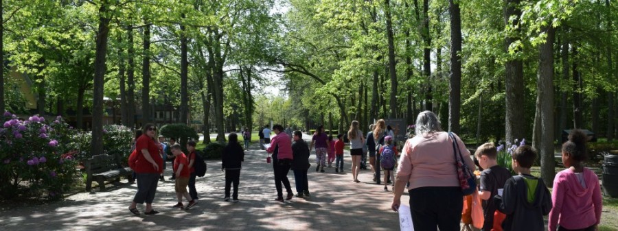 Adults and children walking down along the grounds of WheatonArts