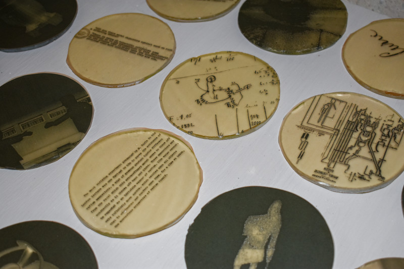 Blueprints, quotes, and various pictures printed on small glass discs. Created by "Emanation 2019" Artist Jo Yarrington