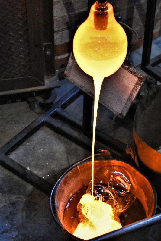 Closeup of a glass orb, part of Jo Yarrington's artwork, "The Uranium Game", receiving an outer coat of molten uranium glass