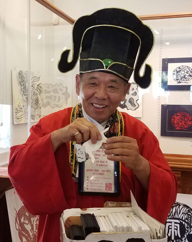 Hou-Tien Cheng smiles while doing a special demonstration of Chinese Papercutting.