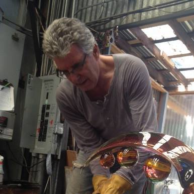 Photo of glass artist Richard Royal creating a glass sculpture.