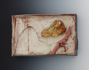 A clay sculpted yellow bird stands on a branch with a brown clay backdrop. Created by Priscilla Dahl.
