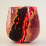 A red cup with a deep black and carmine strip running from bottom to top. Created by Bernard Hohlfeld