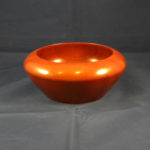 A smooth orange wooden bowl by Thomas Cambria