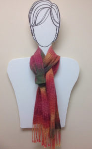 A flat model of a persons upper torso with a flamingo pink, soft yellow, and hunter green color scarf tied neatly around the neck. By Annette Devitt