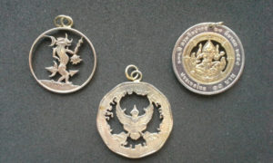 Three metal coin pendants carved by Allan Feinberg