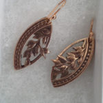 Metal earrings carved by Allan Feinberg with a matching leaf motif