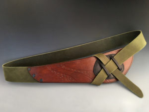 Green leather belt with an orange brown front. Created by Jorge Gil