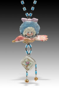 found object necklace by Hilary Greif, a porcelain doll head over a small pink porcelain bird with dangling blue beads.