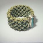 Green and blue beaded bracelet by Naomi Johnson with a tall thin blue glass piece encased in silver in the center