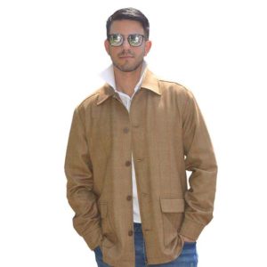 Model poses in a layered look with a brown jacket and a white button up underneath by Catherine Joseph