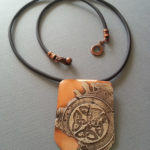 An orange necklace by Kim Lyons with celtic knot designs