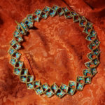 Beaded necklace made of gold colored diamonds filled with green blue and pink beads