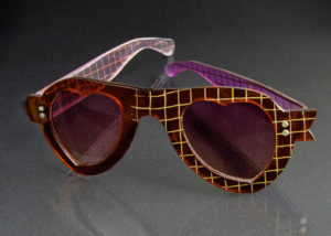 Heart shaped red sunglasses with a yellow cross hatch pattern. Created by Laurie Olefson