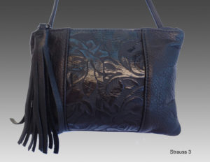 Deep prussian blue purse by Lisa Strauss with a fringe decoration and botanical patterns