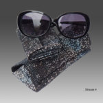 Black sunglasses laid on two matching fish leather eyeglass cases in grey