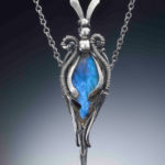 Silver color pendant with a small rabbit head on the top, holding a rich blue semiprecious stone. Created by Judith Hearney