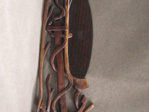 A piece by Gilbert Carey, carved to resemble an anchor with crawling coral or seaweed.