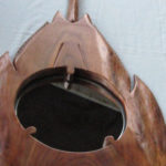 A mirror embedded within a carved, wooden horshoe crab. Created by Gilbert Carey.