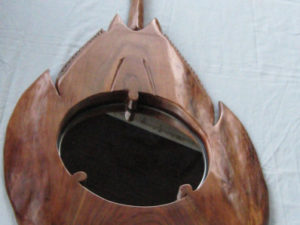 A mirror embedded within a carved, wooden horshoe crab. Created by Gilbert Carey.