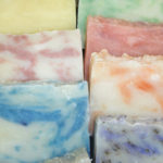 A closeup of ten different types of scented soap from Carol's Scents N' Soaps.