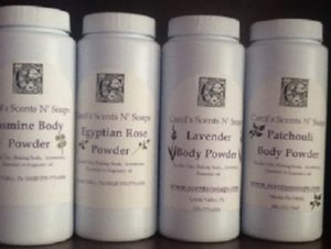 Four bottles of body powder. From left to right, jasmine, Egyptian rose, lavender, and patchouli from Carol's Scents N' Soaps.