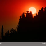 A photograph by Michael Leu of a rich red sunrise rising behind the silhouettes of tall rocks and trees, text in a gray bar across the bottom that says Leu 01 and Sunrise 03.