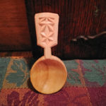 A small, wide wooden spoon carved by Vincent Pettit.