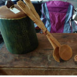 Long wooden tongs leaning against a green container by Vincent Pettit.