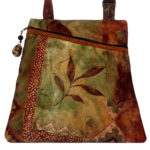 A deep red and green bag with a matching strap and a leaf motif. Created by Agustin Ruiz.