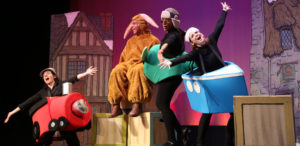 Image displays 4 actors singing onstage with their arms fully extended. One is dressed as a rabbit, the others are dressed a train, plane, and boat.