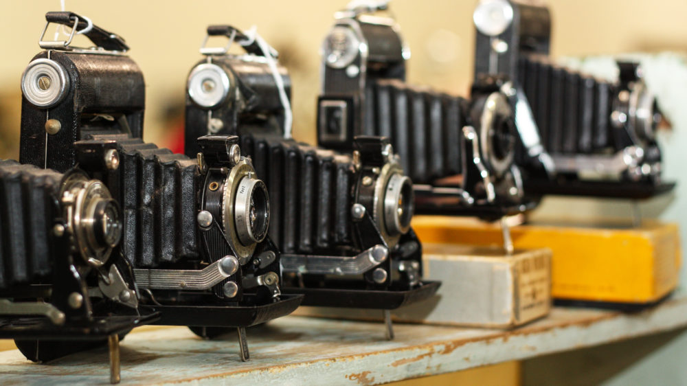 A collection of old cameras lined up side by side.