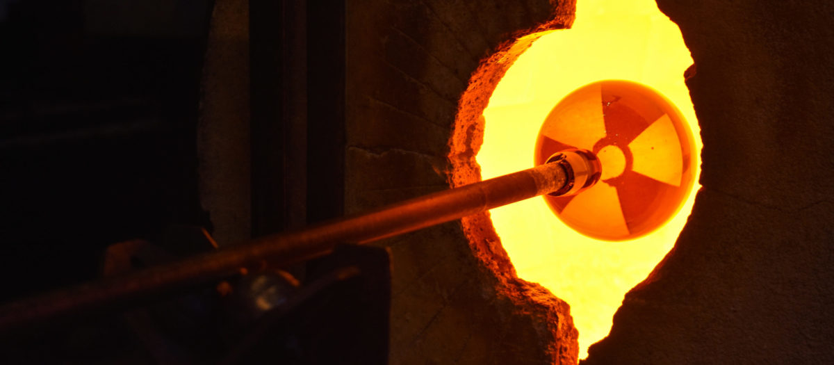 Process shot of a radiation symbol uranium orb by Jo Yarrington in the glass studio glory hole.