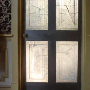 Museum Midden by Karyn Olivier. A door frame with four sections of translucent glass that have been cracked in several places.