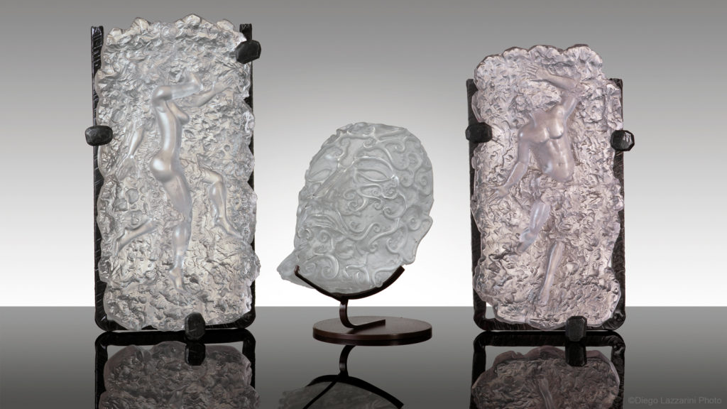 Lucio Bubacco, The Pompeii Series. Three clear relief glass sculptures: a woman, a face, and a man, mounted to stand.